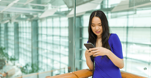 Femeie zâmbind folosind telefonul